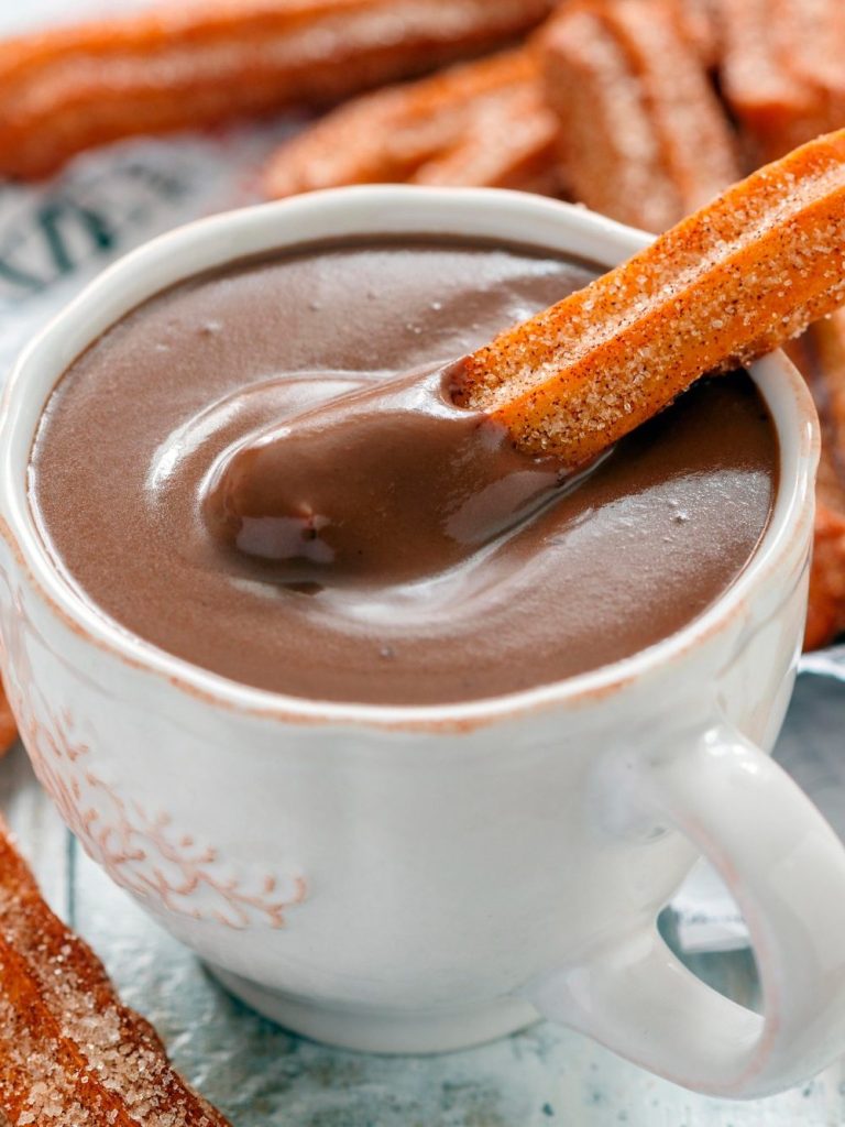 Taza de chocolate caliente acompañada de churros en Urda, Cafetería Patry